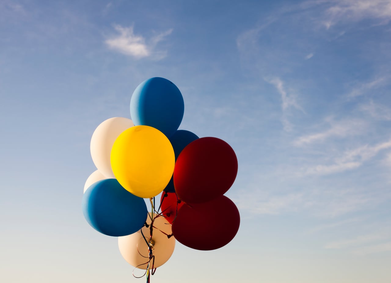 Ein Haufen bunter Luftballons am Himmel.